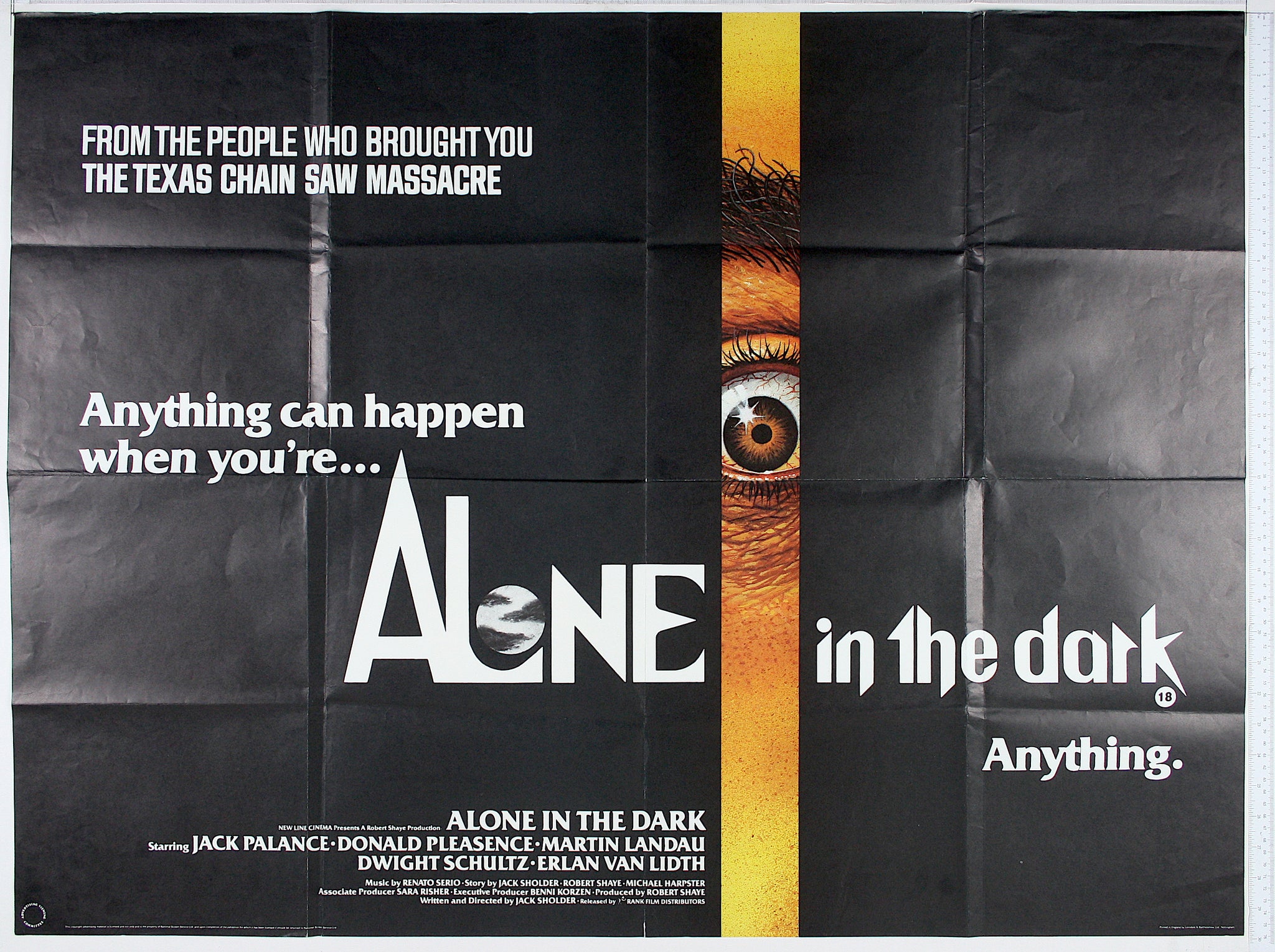 On black ground, a vertical slit off centre reveals a shocked, staring eye. The 'O' of Alone is a full moon.
