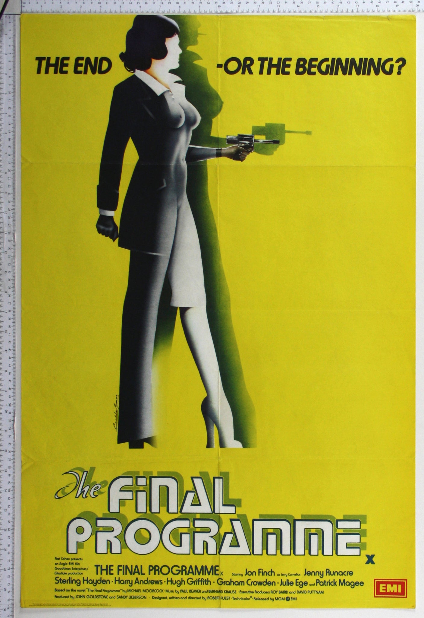 Against a yellow background, an art deco style half male half female figure holds a futuristic gun.