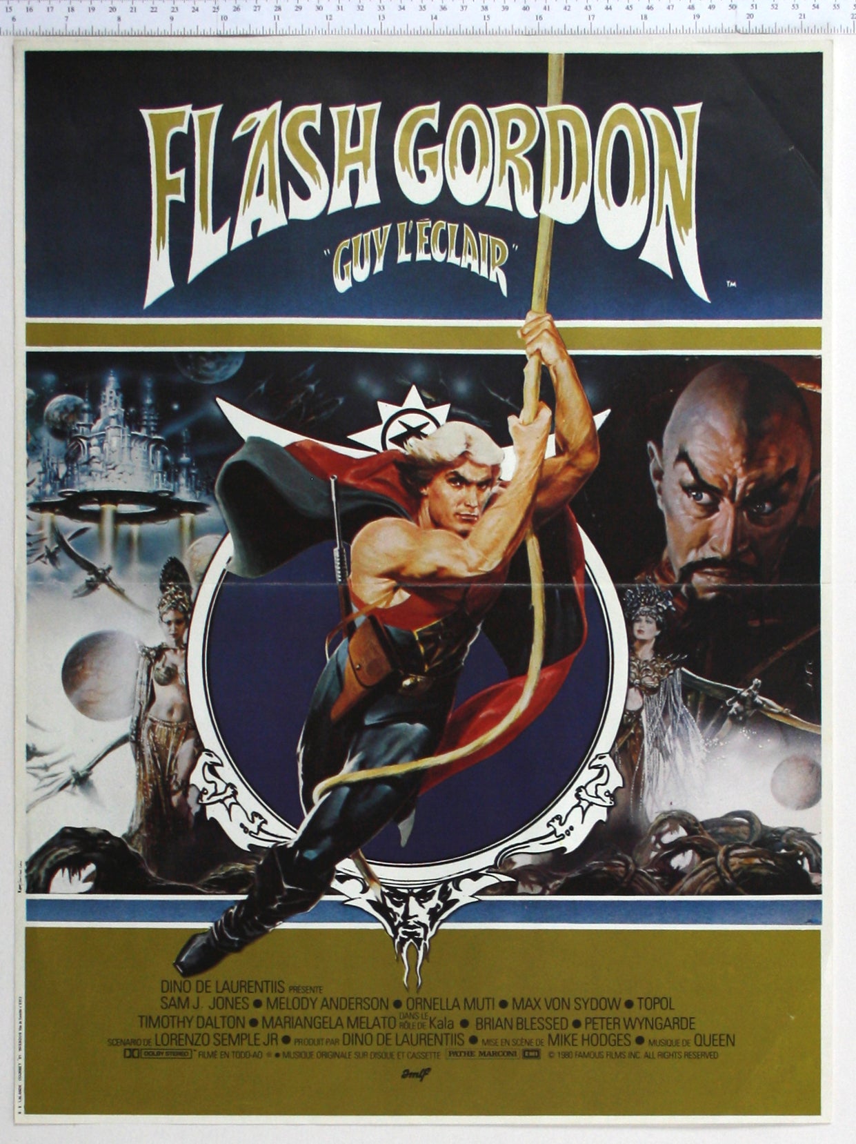 Flash Gordon swinging from vine, surrounding are floating city, evil princess, Dale Arden with Ming watching.