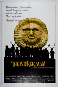 Wooden sun head looms over silhouettes of townspeople dressed in pagan, antlered costumes.